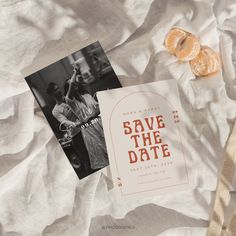 an image of save the date card and orange slices on top of white linens