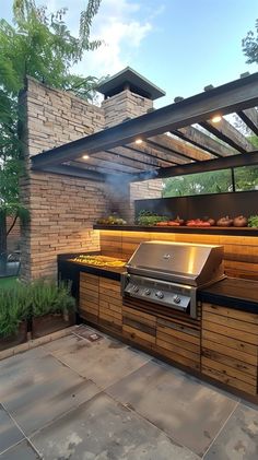 an outdoor kitchen with grill and seating area