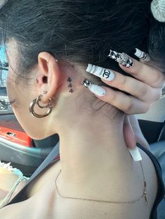 a woman with black and white tattoos on her back neck is sitting in a car