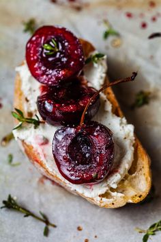 a piece of bread with cream cheese and cherries on it