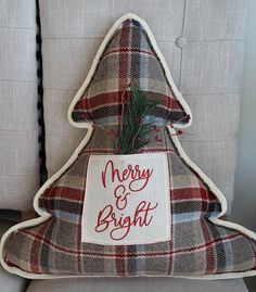 a christmas tree pillow on a chair with a merry and bright sign attached to it