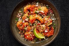 a bowl filled with shrimp and garnish on top of a table