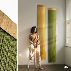 a woman sitting on a chair next to a tall bamboo sculpture and a photo of a woman leaning against the wall