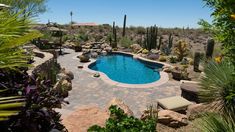 an outdoor pool surrounded by rocks and cactus