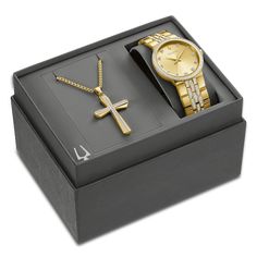 Perfect for gift-giving, this men's boxed set from Bulova showcases a men's watch from the Crystals collection that has sparkling clear crystals on the gold-tone stainless steel bracelet, bezel and the champagne dial. A mineral crystal tops the 40mm stainless steel case, which is water-resistant to 30 meters. The watch features a quartz movement and secures with a push button fold over clasp. A coordinating cross necklace with crystal center is included with the set. Timeless Gold Watch Accessories As A Gift, Modern Yellow Gold Watch Accessories As Gift, Luxury Gold Jewelry With Gift Box, Modern Gold Watch Accessories For Gifts, Gift Yellow Gold Jewelry And Watches With Polished Finish, Modern Gold Watch Accessories As Gift, Yellow Gold Polished Finish Jewelry And Watches For Gift, Gift Yellow Gold Polished Jewelry And Watches, Yellow Gold Watches With Diamond Hour Markers As Gift