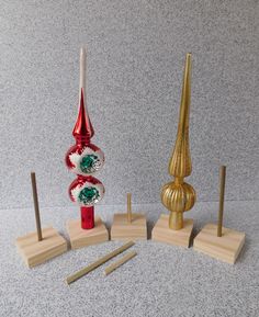 three different types of christmas decorations on wooden bases and stands in front of a gray wall