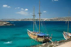 two boats are docked in the blue water