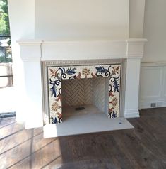 an empty fireplace in the middle of a room with wood flooring and white walls