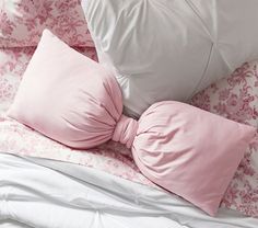 pink and white pillows with bows on them