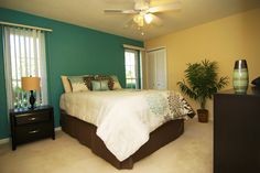 a bedroom with green walls and white bedding in the center, along with two nightstands