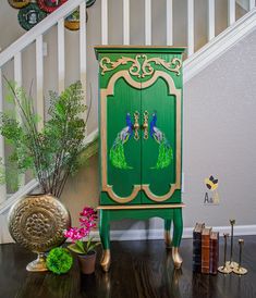 a green cabinet sitting on top of a hard wood floor next to a stair case