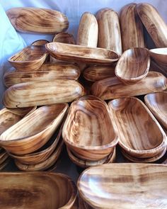 many wooden bowls and spoons stacked on top of each other