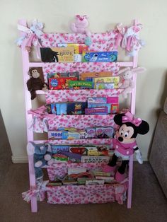 a pink book shelf filled with books and stuffed animals