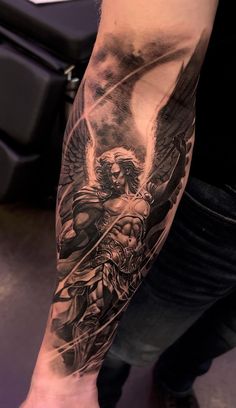 a man's arm with an angel tattoo on it