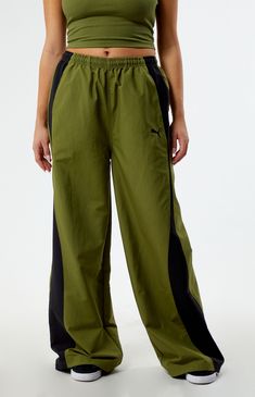 Elevate your athleisure wardrobe with Puma's Green Dare To Relaxed Parachute Pants. Unleash comfort and style with these relaxed-fit pants, boasting a trendy parachute design that seamlessly blends performance and fashion for a bold, sporty look.


	Solid color parachute pants
	13.5" rise
	29" inseam
	Lightweight construction
	High-rise
	Interior drawstring waistband
	Contrast side stripes
	Side hand pockets
	Back flap pocket
	Puma embroidery
	Bungee drawcord ankle cuffs
	Relaxed fit Parachute Design, Athleisure Wardrobe, Ankle Cuffs, Fit Pants, Sporty Look, Side Stripe, Drawstring Waistband, Workout Pants, Model Measurements