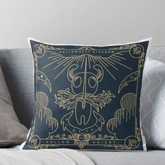 a black and gold throw pillow with an image of a bird on it's back