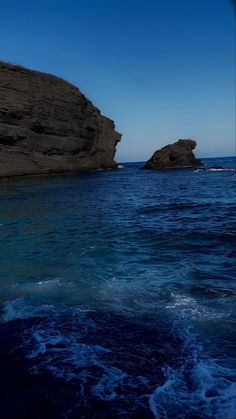 an ocean view with rocks and blue water