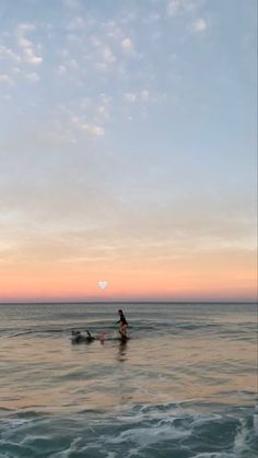 a person riding a surfboard on top of a wave in the ocean at sunset