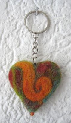 a heart shaped keychain hanging on a white surface