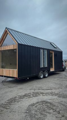 a tiny house is parked in the dirt