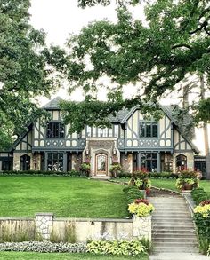 a large house sitting in the middle of a lush green field with lots of trees