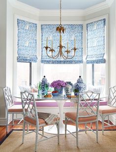 a dining room table with chairs and a chandelier hanging from it's ceiling