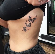 a woman's stomach with three butterflies on her side, and stars in the back