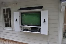 an entertainment center built into the side of a house with a television mounted on it