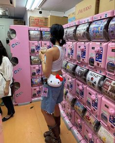 a woman standing in front of a pink shelf with hello kitty on it's back