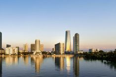 the city skyline is reflected in the water