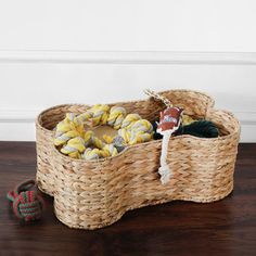 a wicker basket filled with toys on top of a wooden floor