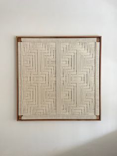 a white wall hanging on the side of a wall next to a wooden framed object