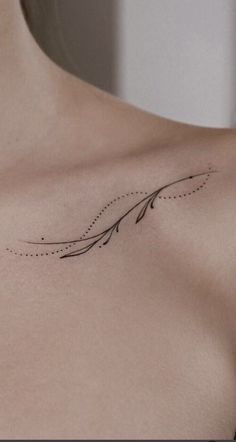 a woman's chest with an arrow tattoo on it