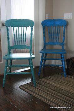 two blue chairs sitting next to each other in front of a door with a rug on the floor