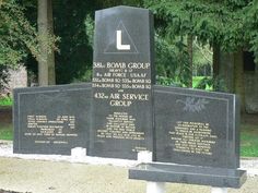 three black headstones with names on them in front of trees and grass area