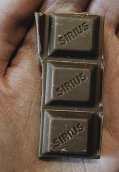 two pieces of chocolate with the word sirius spelled on them