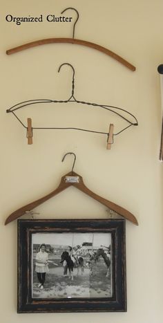 an old photo hangs on a coat hanger with clothes pins attached to the hooks