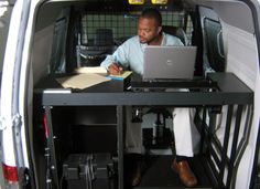 a woman sitting at a desk in the back of a van