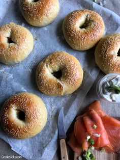 bagels with cream cheese and salmon on a paper towel next to a small bowl of ranch dressing