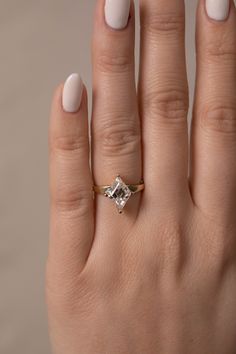 a woman's hand with a ring on it and a diamond in the middle