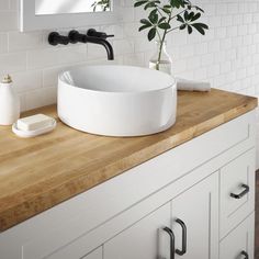 a white sink sitting on top of a wooden counter