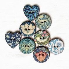 six buttons with different designs on them are arranged in the shape of a flower and leaves