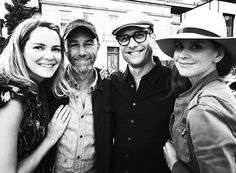 three people posing for the camera with one woman wearing a cowboy hat and another man in a black shirt