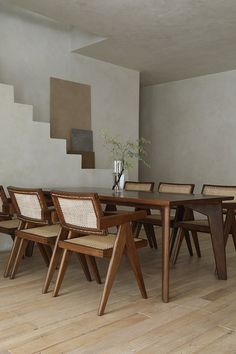 a dining room table and chairs in front of stairs