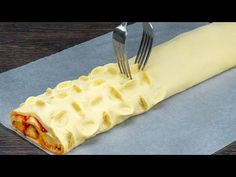 a fork sticking into a pastry on top of a piece of wax paper with cheese