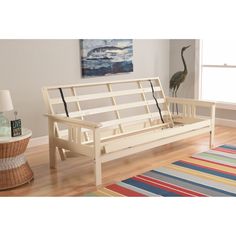 a white wooden bench sitting on top of a hard wood floor next to a window