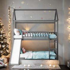 a bunk bed with a slide in front of it and christmas lights on the wall