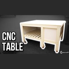 a small white table with wheels on it and the words cnc table above it