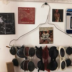 some sunglasses are hanging on a wall with pictures and magnets attached to the wall