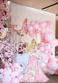 a barbie birthday party with pink balloons and butterflies on the wall, including a princess balloon arch